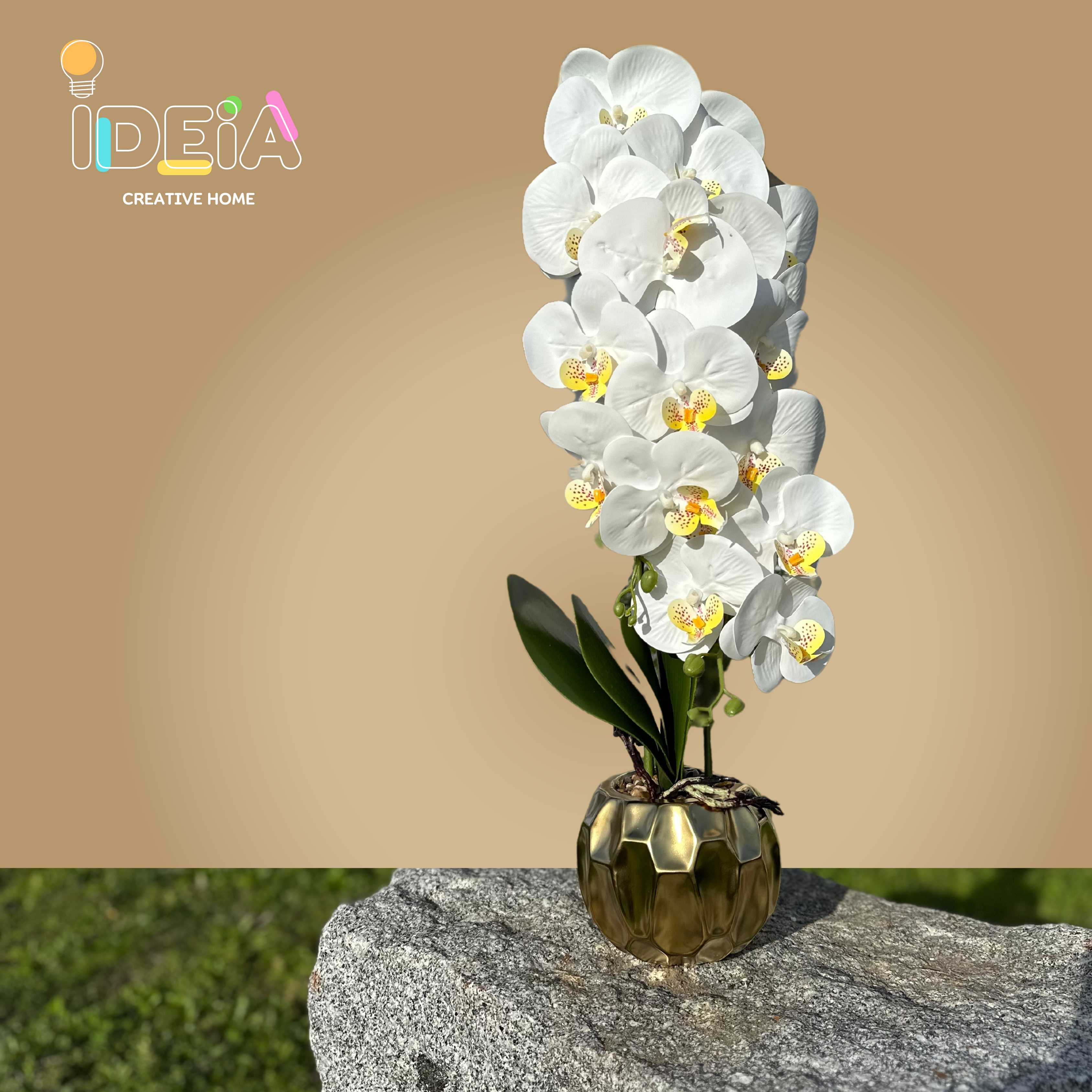 Vaso dourado com orquídea artificial